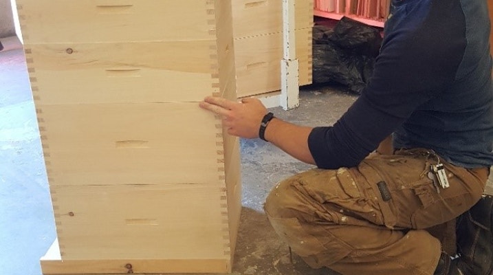 Guy working on a bee hive